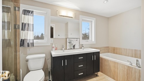 Bathroom featuring double vanity, a garden tub, healthy amount of natural light, and a shower - 11520 78 Avenue Nw, Edmonton, AB - Indoor Photo Showing Bathroom