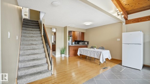 Kitchen featuring freestanding refrigerator, wood finish cabinetry, light tile patterned flooring, and light countertops - 11520 78 Avenue Nw, Edmonton, AB - Indoor