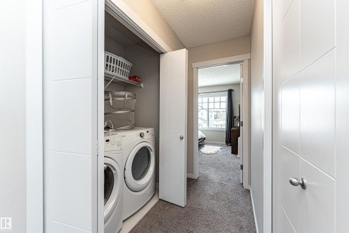Laundry area featuring a textured ceiling, carpet, and washer and dryer - 4008 Allan Crescent, Edmonton, AB - Indoor Photo Showing Laundry Room