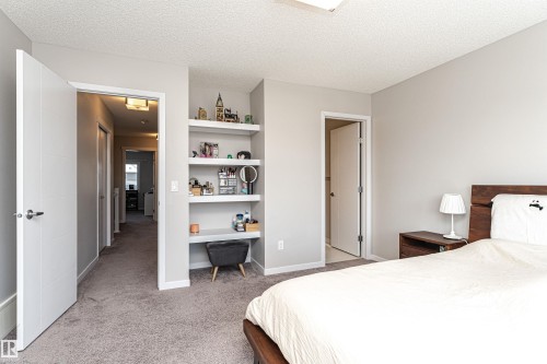 Bedroom featuring light colored carpet, a textured ceiling, and built in desk - 4008 Allan Crescent, Edmonton, AB - Indoor Photo Showing Bedroom