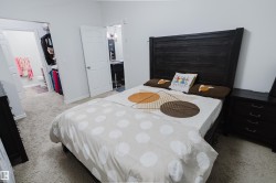 Bedroom with light colored carpet and connected bathroom - 