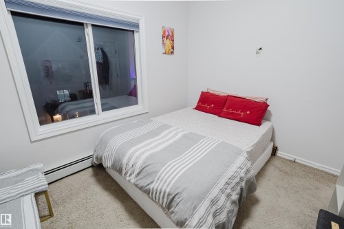 Bedroom featuring baseboard heating and light carpet - 415 2203 44 Avenue, Edmonton, AB - Indoor Photo Showing Bedroom