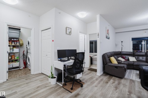 Office area featuring a textured ceiling, light wood finished floors, and stacked washer and dryer - 415 2203 44 Avenue, Edmonton, AB - Indoor