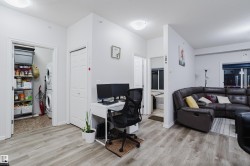 Office area featuring a textured ceiling, light wood finished floors, and stacked washer and dryer - 