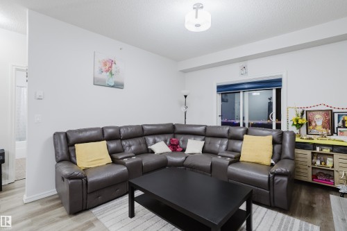 Living room with a textured ceiling and wood finished floors - 415 2203 44 Avenue, Edmonton, AB - Indoor Photo Showing Living Room