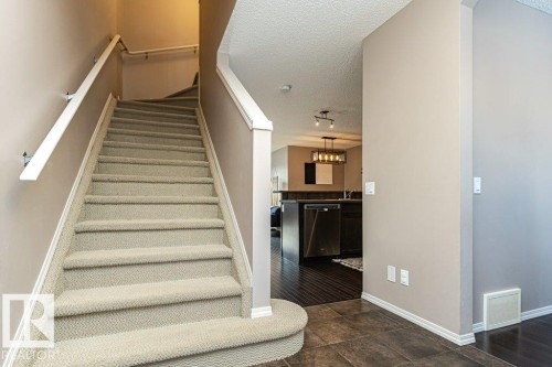 Staircase with baseboards and a textured ceiling - 6649 Cardinal Road Sw, Edmonton, AB - Indoor Photo Showing Other Room