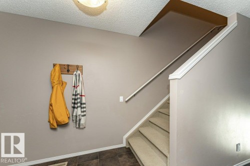 Staircase with a textured ceiling and tile patterned flooring - 6649 Cardinal Road Sw, Edmonton, AB - Indoor Photo Showing Other Room