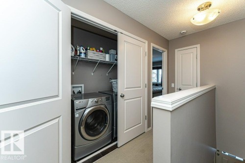 Laundry area featuring washer / dryer and a textured ceiling - 6649 Cardinal Road Sw, Edmonton, AB - Indoor Photo Showing Laundry Room