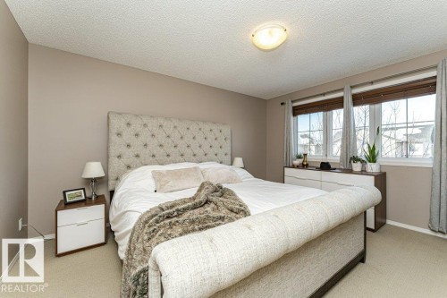 Bedroom featuring a textured ceiling and light colored carpet - 6649 Cardinal Road Sw, Edmonton, AB - Indoor Photo Showing Bedroom
