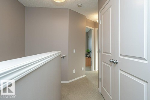 Hall featuring light colored carpet and a textured ceiling - 6649 Cardinal Road Sw, Edmonton, AB - Indoor Photo Showing Other Room