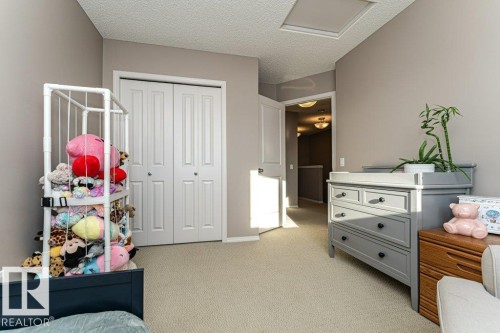Bedroom with light carpet, a closet, and a textured ceiling - 6649 Cardinal Road Sw, Edmonton, AB - Indoor Photo Showing Bedroom