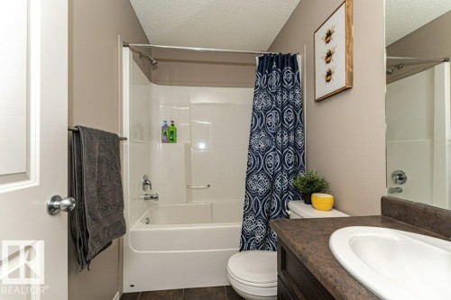 Full bath featuring a textured ceiling, vanity, and shower / bathtub combination with curtain - 6649 Cardinal Road Sw, Edmonton, AB - Indoor Photo Showing Bathroom