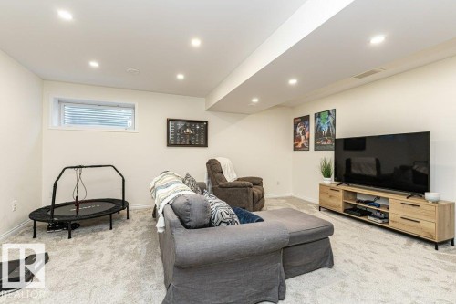 Living room with light carpet and recessed lighting - 6649 Cardinal Road Sw, Edmonton, AB - Indoor Photo Showing Other Room