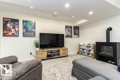 Living room with carpet floors, recessed lighting, and a wood stove - 6649 Cardinal Road Sw, Edmonton, AB - Indoor Photo Showing Living Room