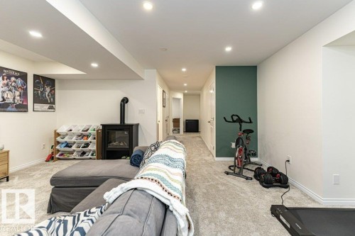 Exercise room featuring recessed lighting, light carpet, and a wood stove - 6649 Cardinal Road Sw, Edmonton, AB - Indoor