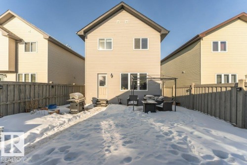 Snow covered back of property with outdoor furniture, a fenced backyard, and a patio area - 6649 Cardinal Road Sw, Edmonton, AB - Outdoor With Deck Patio Veranda With Exterior