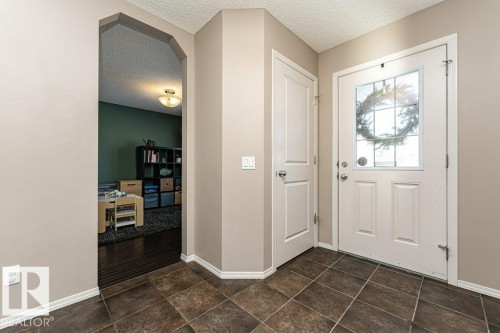 Entrance foyer with arched walkways, a textured ceiling, and dark stone finish flooring - 6649 Cardinal Road Sw, Edmonton, AB - Indoor Photo Showing Other Room
