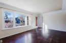 Empty room with dark wood-style flooring, crown molding, and a textured ceiling - 10511 80 Street, Edmonton, AB 