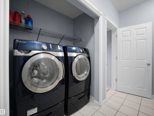 Laundry area with independent washer and dryer and light tile patterned floors - 6115 11 Avenue, Edmonton, AB - Indoor Photo Showing Laundry Room