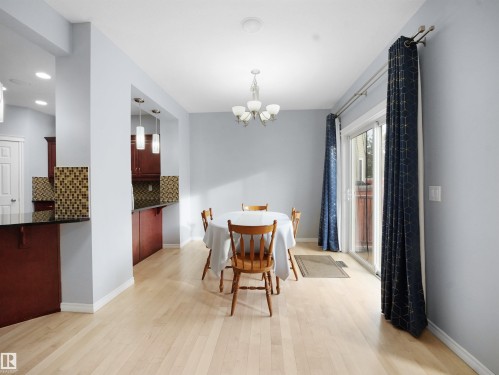 Dining space featuring light wood-type flooring and a chandelier - 6115 11 Avenue, Edmonton, AB - Indoor Photo Showing Dining Room