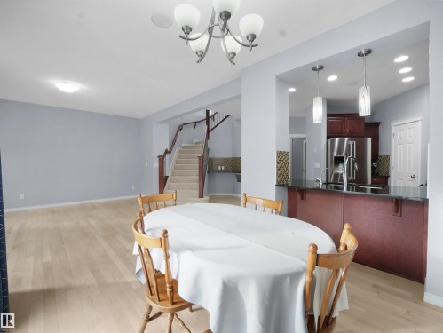 Dining area with light wood-style floors and a chandelier - 6115 11 Avenue, Edmonton, AB - Indoor Photo Showing Dining Room