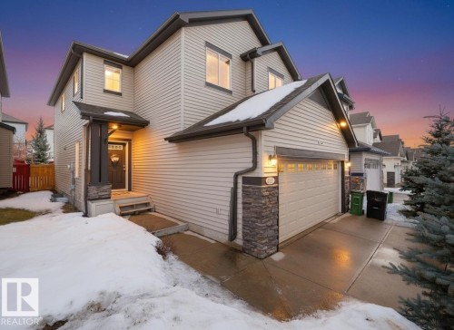 Traditional-style house featuring concrete driveway and stone siding - 6115 11 Avenue, Edmonton, AB - Outdoor