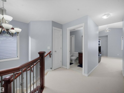 Hall with an upstairs landing, light carpet, and suspended lighting - 6115 11 Avenue, Edmonton, AB - Indoor Photo Showing Other Room