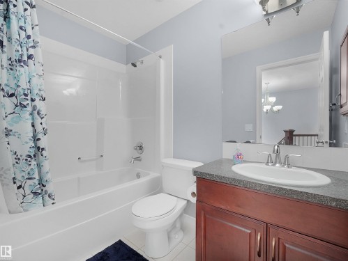 Bathroom with vanity, shower / tub combo, and tile patterned flooring - 6115 11 Avenue, Edmonton, AB - Indoor Photo Showing Bathroom