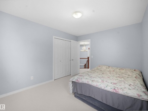 Bedroom with light carpet, a closet, and hanging lights - 6115 11 Avenue, Edmonton, AB - Indoor Photo Showing Bedroom