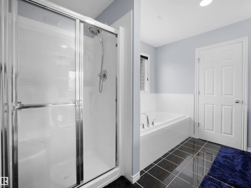 Bathroom featuring a bath, a shower stall, and dark tile patterned floors - 6115 11 Avenue, Edmonton, AB - Indoor Photo Showing Bathroom