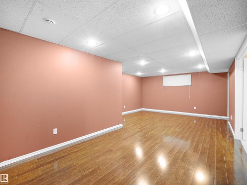 Finished below grade area with a drop ceiling and wood finished floors - 6115 11 Avenue, Edmonton, AB - Indoor Photo Showing Basement
