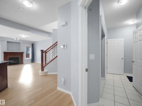 Hall featuring baseboards and light wood-style floors - 6115 11 Avenue, Edmonton, AB - Indoor Photo Showing Other Room With Fireplace