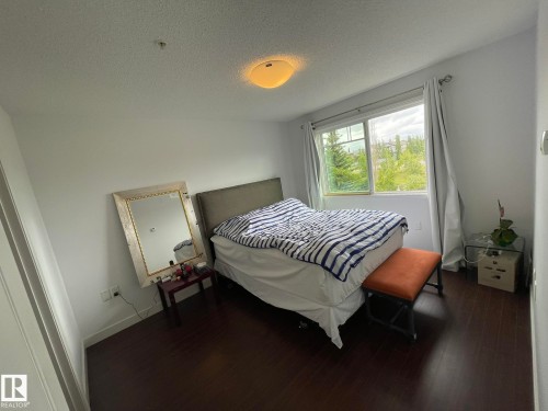 Bedroom featuring a textured ceiling and dark wood-style floors - 207 7021 South Terwillegar Drive, Edmonton, AB - Indoor Photo Showing Bedroom