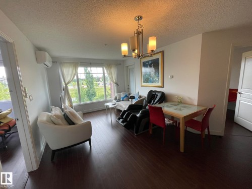 Dining room with a textured ceiling, hanging lights, and dark wood-type flooring - 207 7021 South Terwillegar Drive, Edmonton, AB - Indoor Photo Showing Other Room