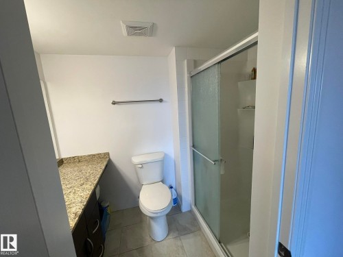 Full bath with a stall shower, vanity, and light tile patterned flooring - 207 7021 South Terwillegar Drive, Edmonton, AB - Indoor Photo Showing Bathroom