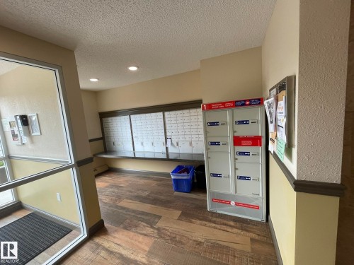 View of property's community with mail area, a textured ceiling, and recessed lighting - 207 7021 South Terwillegar Drive, Edmonton, AB - Indoor Photo Showing Other Room