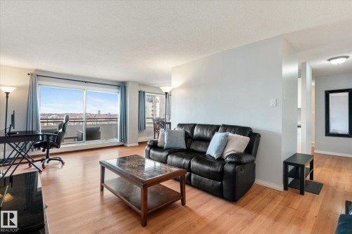 Living room featuring light wood finished floors, a desk, and a textured ceiling - 304 9725 106 Street, Edmonton, AB - Indoor Photo Showing Living Room