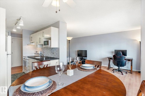 Dining room featuring light wood-style flooring, ceiling fan, a textured ceiling, a desk, and track lighting - 304 9725 106 Street, Edmonton, AB - Indoor
