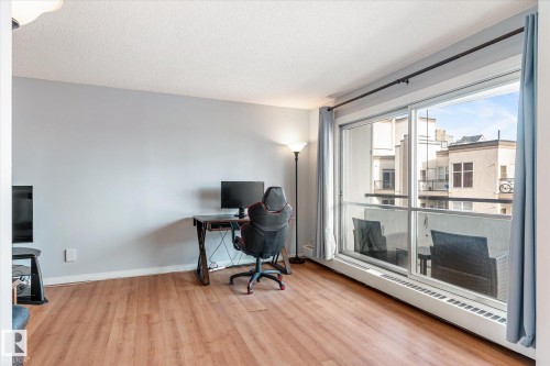 Office with a baseboard radiator, light wood-style floors, and a textured ceiling - 304 9725 106 Street, Edmonton, AB - Indoor