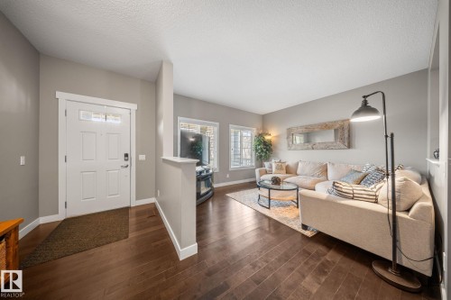 Foyer entrance with a textured ceiling and dark wood-type flooring - 8107 224 Street Nw, Edmonton, AB - Indoor Photo Showing Living Room