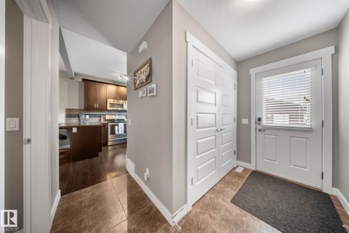 Entrance foyer featuring dark tile patterned floors and a textured ceiling - 8107 224 Street Nw, Edmonton, AB - Indoor Photo Showing Other Room