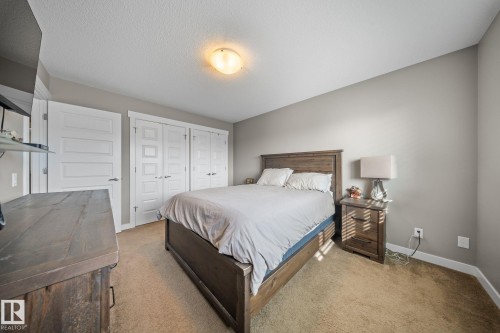 Carpeted bedroom featuring baseboards and a textured ceiling - 8107 224 Street Nw, Edmonton, AB - Indoor Photo Showing Bedroom