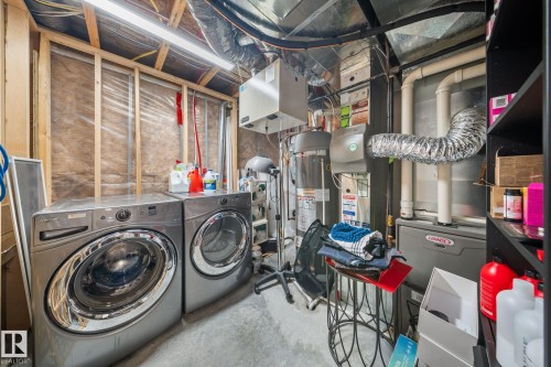 Laundry area with concrete floors, independent washer and dryer, and water heater - 8107 224 Street Nw, Edmonton, AB - Indoor Photo Showing Laundry Room