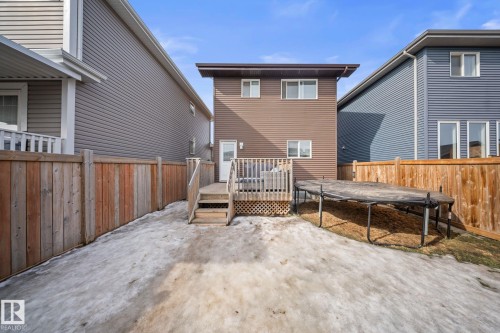Rear view of property featuring a trampoline, a fenced backyard, and a deck - 8107 224 Street Nw, Edmonton, AB - Outdoor With Exterior