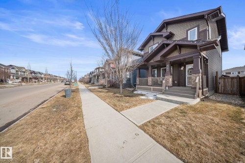 View of side of property featuring a porch and a residential view - 8107 224 Street Nw, Edmonton, AB - Outdoor With Facade