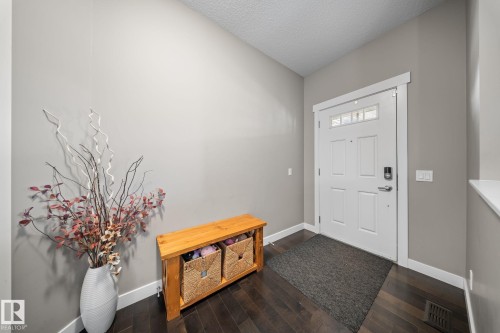 Foyer entrance with dark wood-type flooring and a textured ceiling - 8107 224 Street Nw, Edmonton, AB - Indoor Photo Showing Other Room