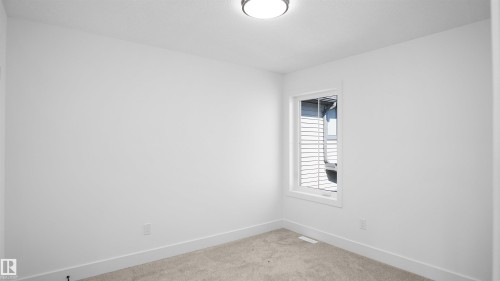 Empty room featuring baseboards and light carpet - 711 31 Avenue, Edmonton, AB - Indoor Photo Showing Other Room