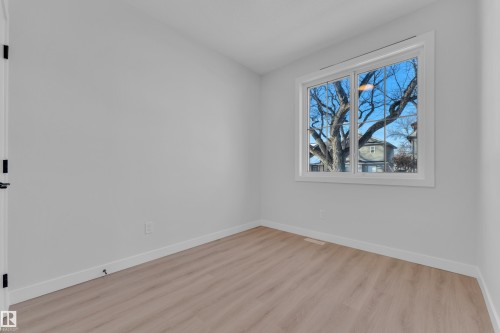 Unfurnished room featuring baseboards and light wood-style floors - 9531/ 9533 115 Ave, Edmonton, AB - Indoor Photo Showing Other Room