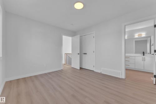 Unfurnished bedroom with light wood finished floors, connected bathroom, and a closet - 9531/ 9533 115 Ave, Edmonton, AB - Indoor Photo Showing Other Room