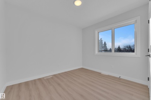 Spare room featuring baseboards and light wood-style flooring - 9531/ 9533 115 Ave, Edmonton, AB - Indoor Photo Showing Other Room